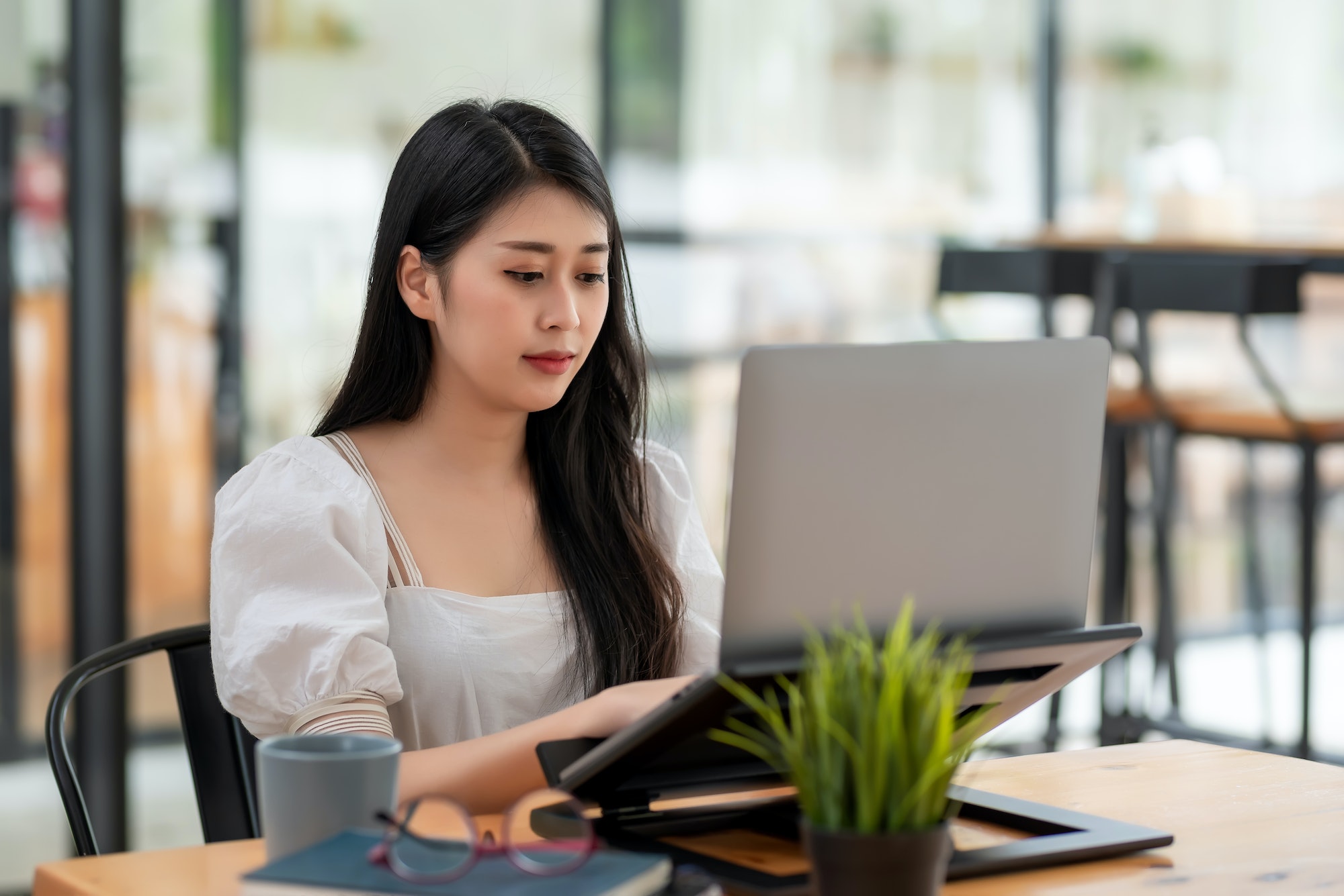 Image of young Asian businesswoman sitting using laptop computer at the office.